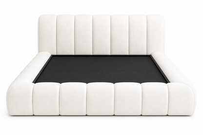 Low-profile artisanal bed base with soft vertical stitch detailing